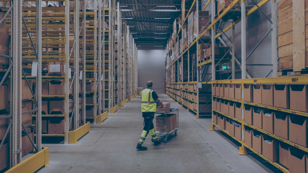 Male moving the shipments using a trolley in a warehouse